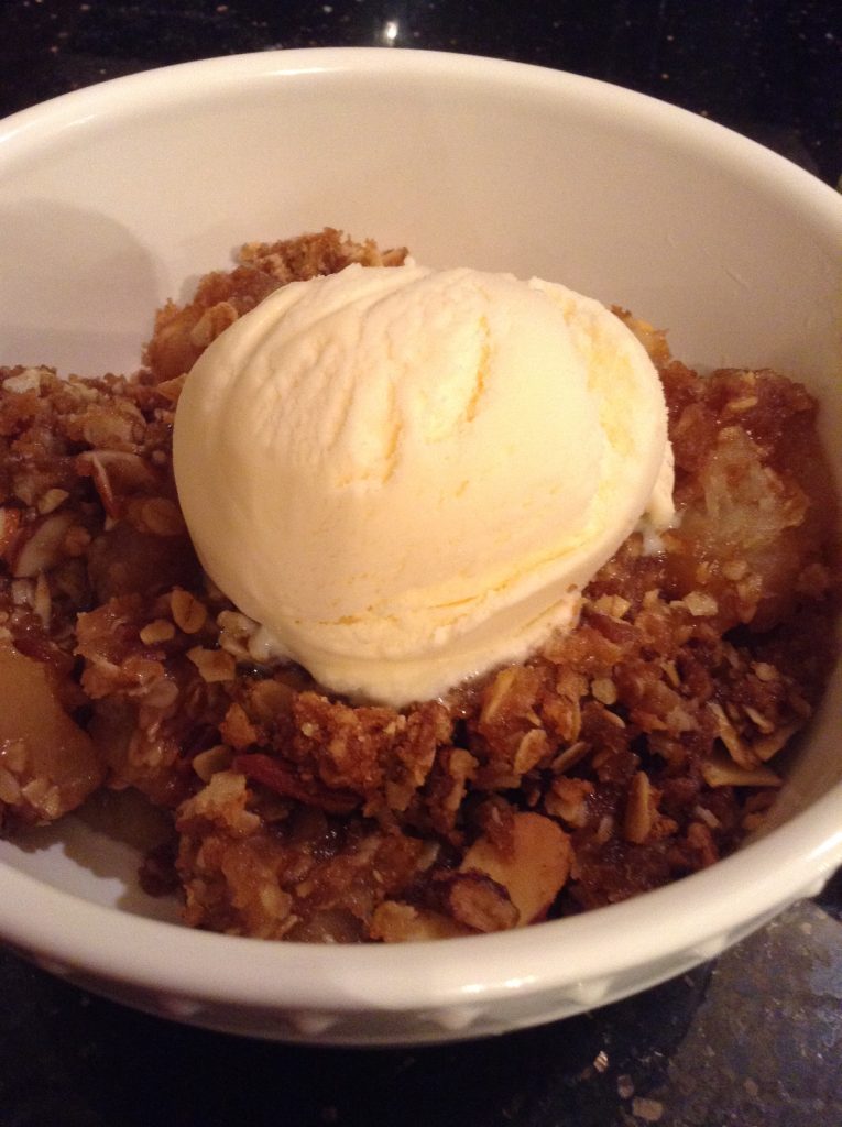 Picture of a single serving of apple crisp a la mode (served with ice cream).