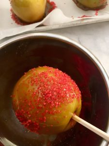 Photo of sprinkles on caramel apple.