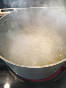 Photo of boiling water with olive oil and salt.