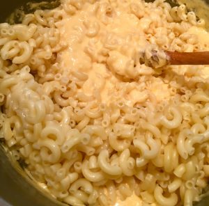 Photo of stirring macaroni into the cheese sauce. 
