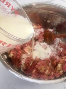 Photo of adding cream to meatloaf mixture. 