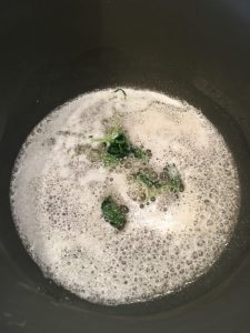 Photo of melted butter with sage leaves.