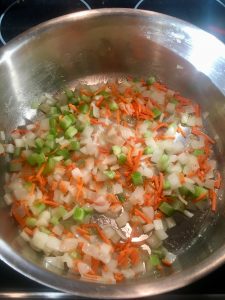 Photo of onions, carrots, and celery cooking. 