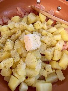 Photo of adding butter to potatoes and bacon.