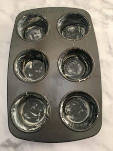 Photo of buttered muffin tins.