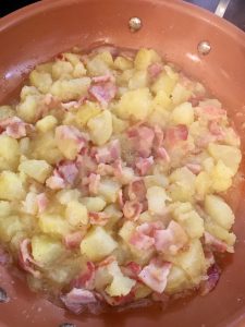 Photo of potatoes and bacon cooking. 