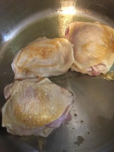Chicken cooking on the stove top.