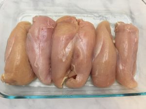 Raw chicken breasts rubbed with oil.