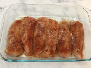 Spice rubbed raw chicken breasts.