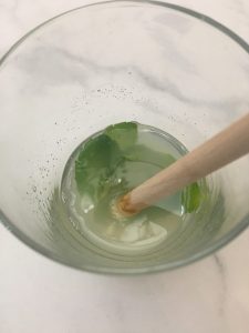 Mint being muddled with lime juice.