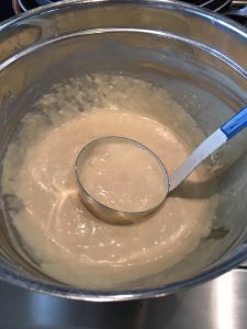 Photo of ladle of pancake batter.