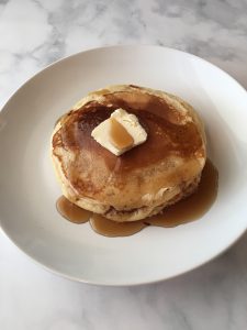 Photo of pancakes with butter and syrup.