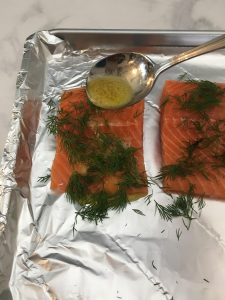 Photo of pouring butter sauce on salmon. 