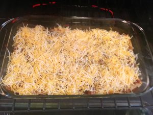 Photo of adding cheese to the enchiladas.