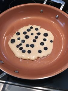Photo of blueberry pancakes cooking.