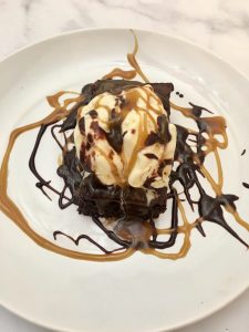 Photo of Chocolate Brownies with Vanilla Ice Cream and Caramel and Chocolate Sauce.