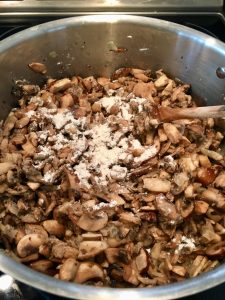 Photo of adding flour to the mushrooms.