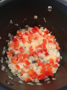 Photo of onions and red peppers cooking.