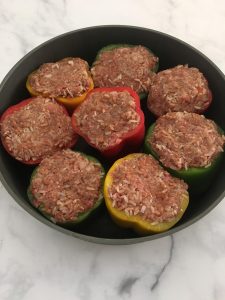 Photo of bell peppers stuffed with meat mixture. 