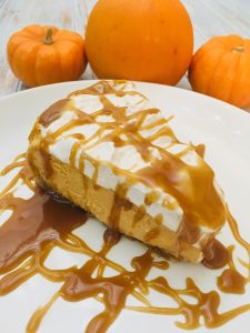 Photo of Pumpkin Cheesecake with Spiced Whipped Cream Frosting and Caramel Sauce. 