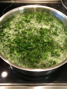 Photo of spinach cooking in water.