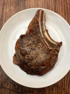 Photo of a big juicy bone-in rib eye steak. 