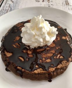 Chocolate Pancake with plenty of chocolate syrup and whipped cream.