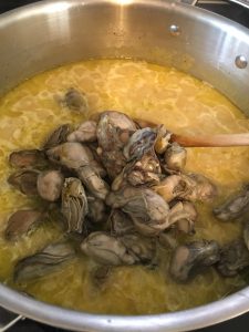 Whole canned oysters being added to the rice.