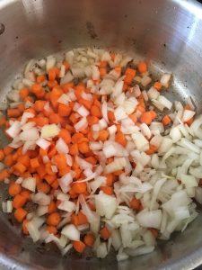 Carrots and onions added to the pan. 