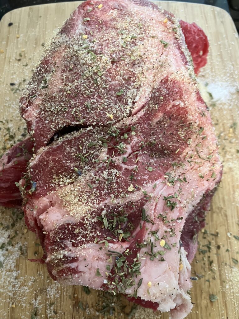 Chuck roast beef with herbs before cooking for Italian Pot Roast.