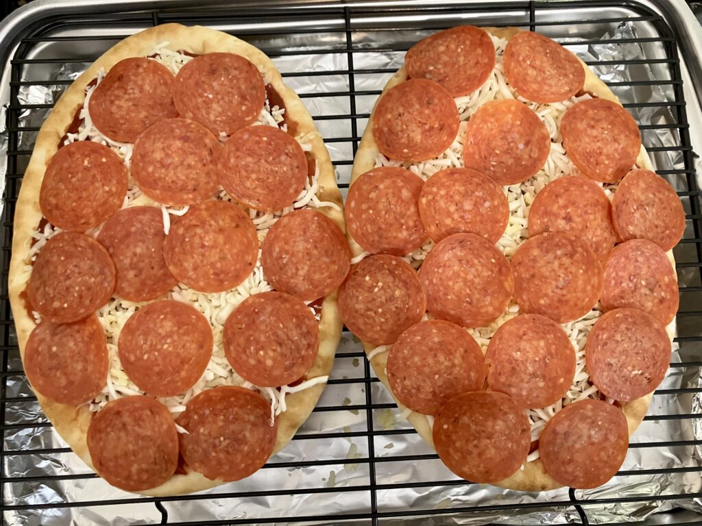 Top flatbreads with pepperoni. 
