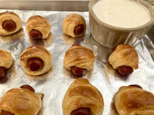 Mini crescent roll hotdogs (pigs in a blanket) with Spicy Ranch Dressing.
