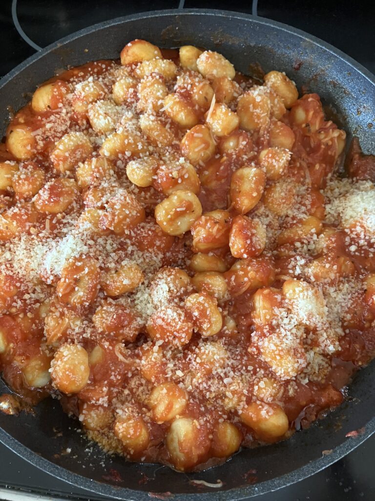 Gnocchi in tomato sauce topped with Parmesan and Romano cheeses. 