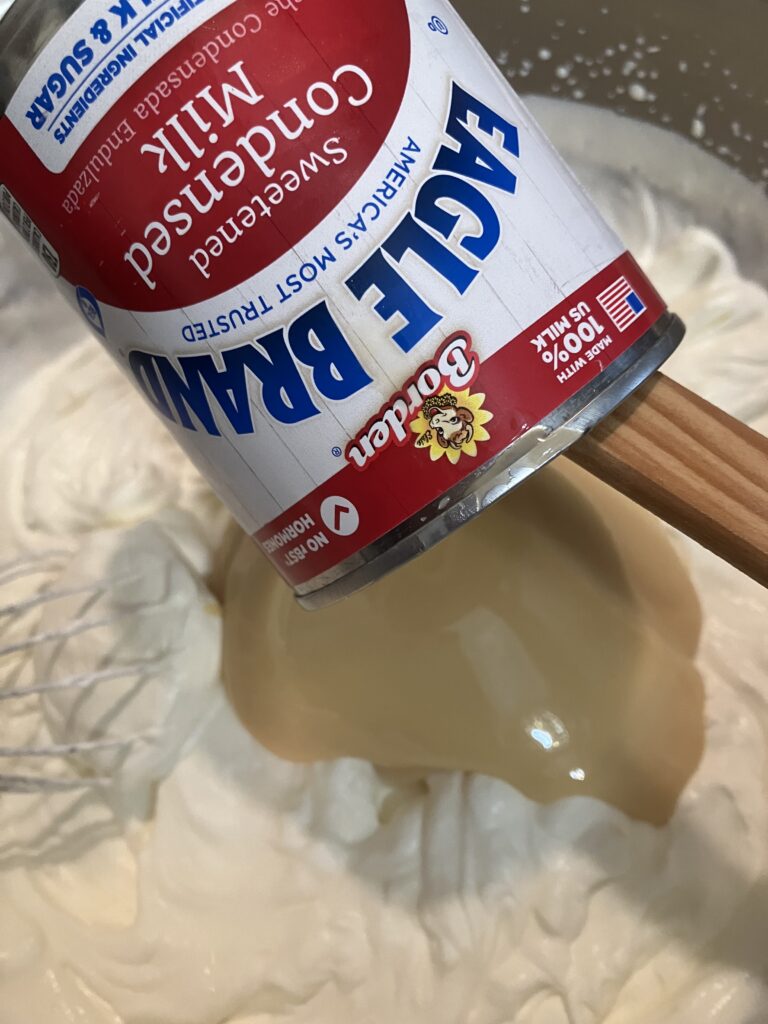 Add sweetened condensed milk to whipped cream. 