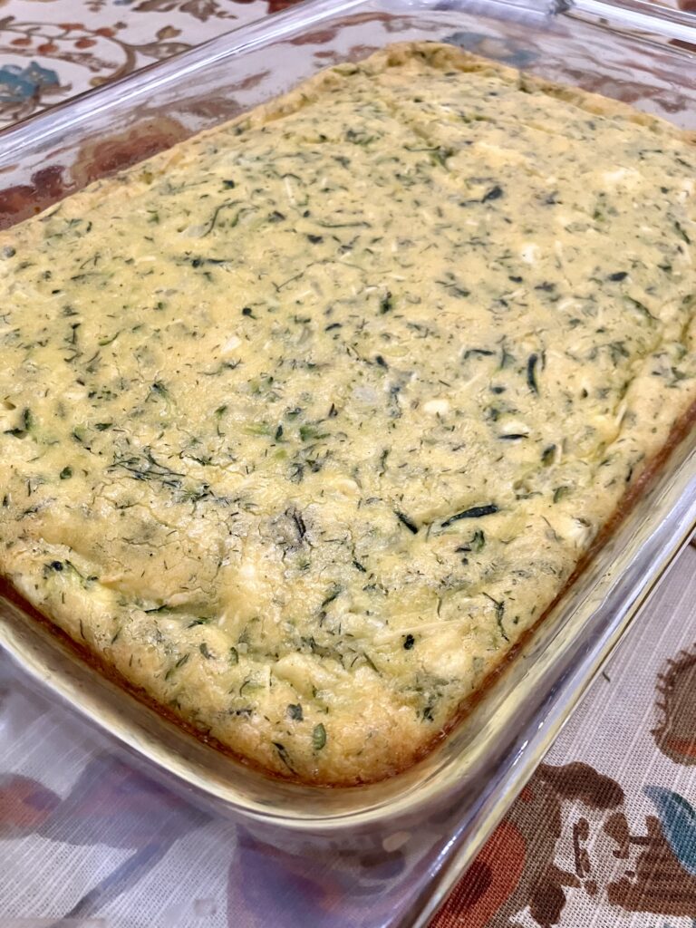 Sfougato is a Greek zucchini, feta cheese, and egg breakfast dish that is baked in the oven.  It's similar to a crustless quiche.