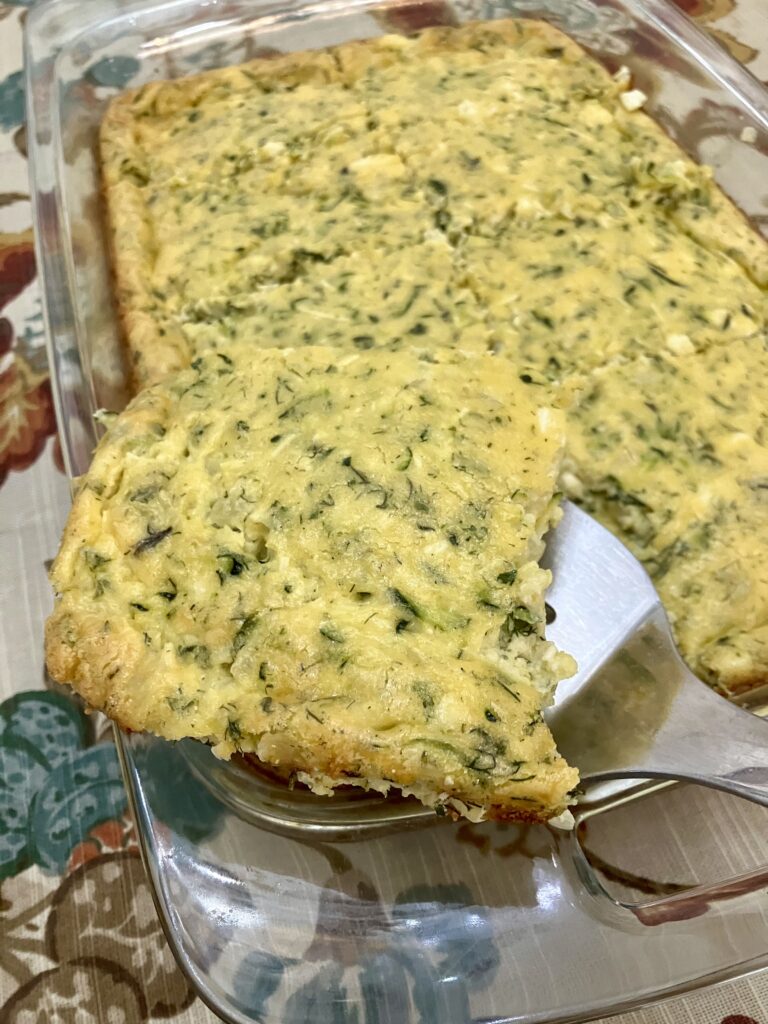 Sfougato is a Greek zucchini, feta cheese, and egg breakfast dish that is baked in the oven.  It's similar to a crustless quiche.