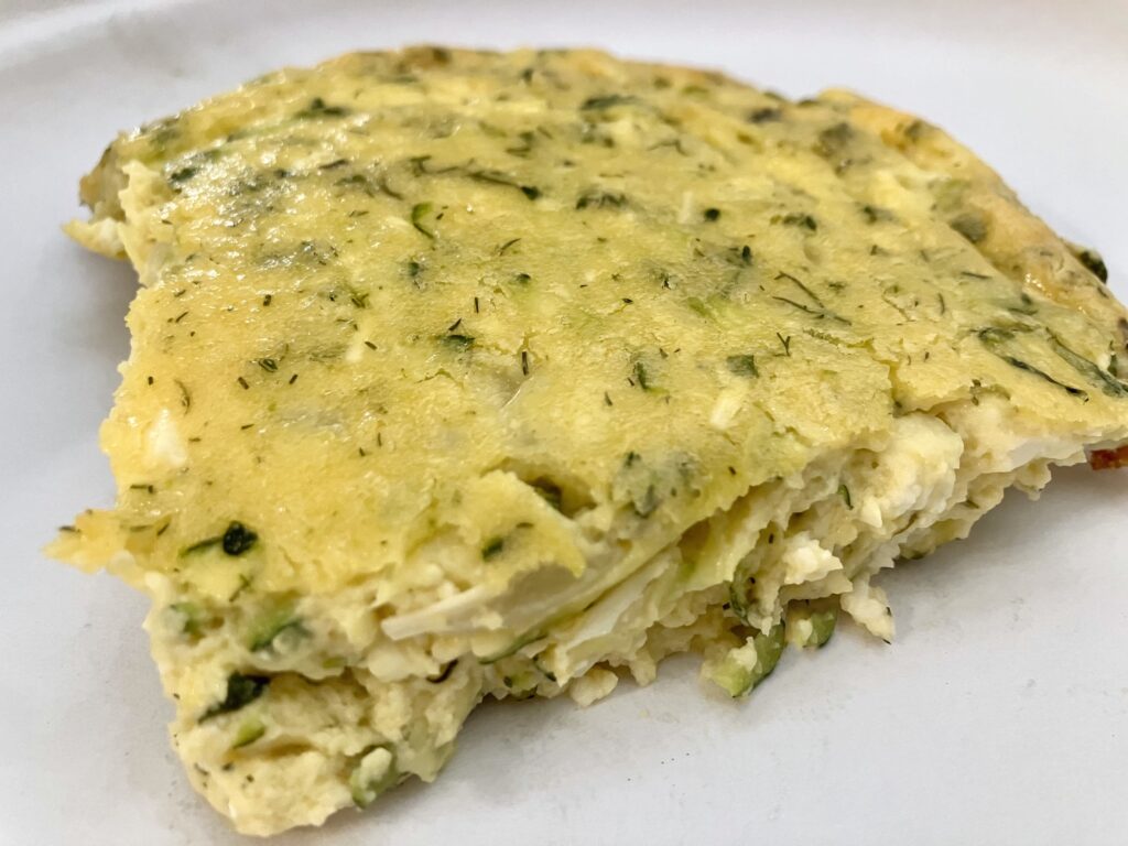 Sfougato is a Greek zucchini, feta cheese, and egg breakfast dish that is baked in the oven.  It's similar to a crustless quiche.