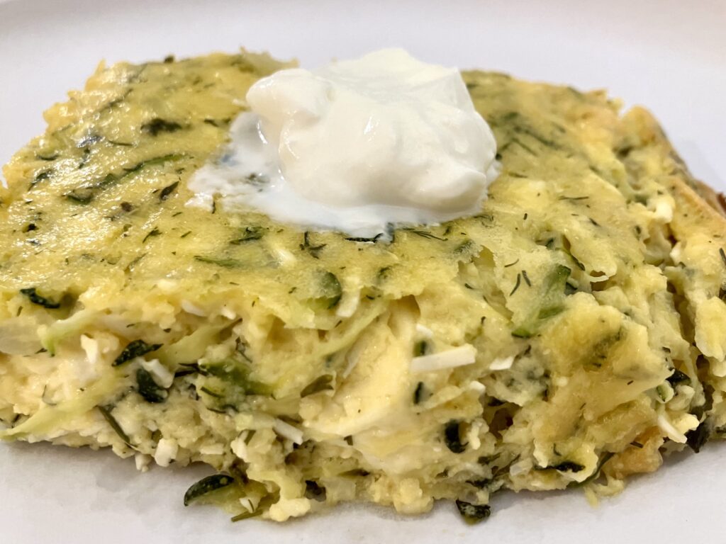 Sfougato is a Greek zucchini, feta cheese, and egg breakfast dish that is baked in the oven.  It's similar to a crustless quiche.