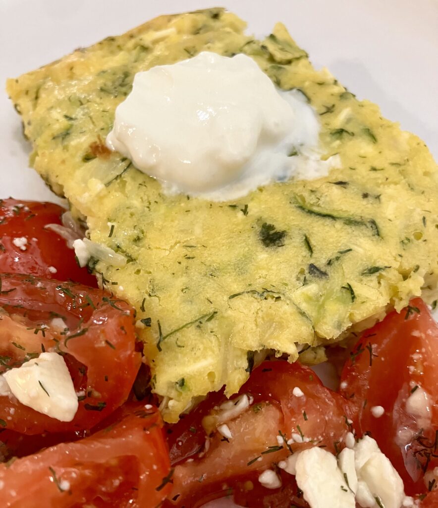 Sfougato is a Greek zucchini, feta cheese, and egg breakfast dish that is baked in the oven.  It's similar to a crustless quiche.