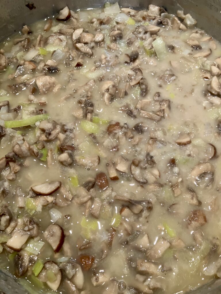 Pour in the Sherry and chicken stock into the mushroom mixture. 