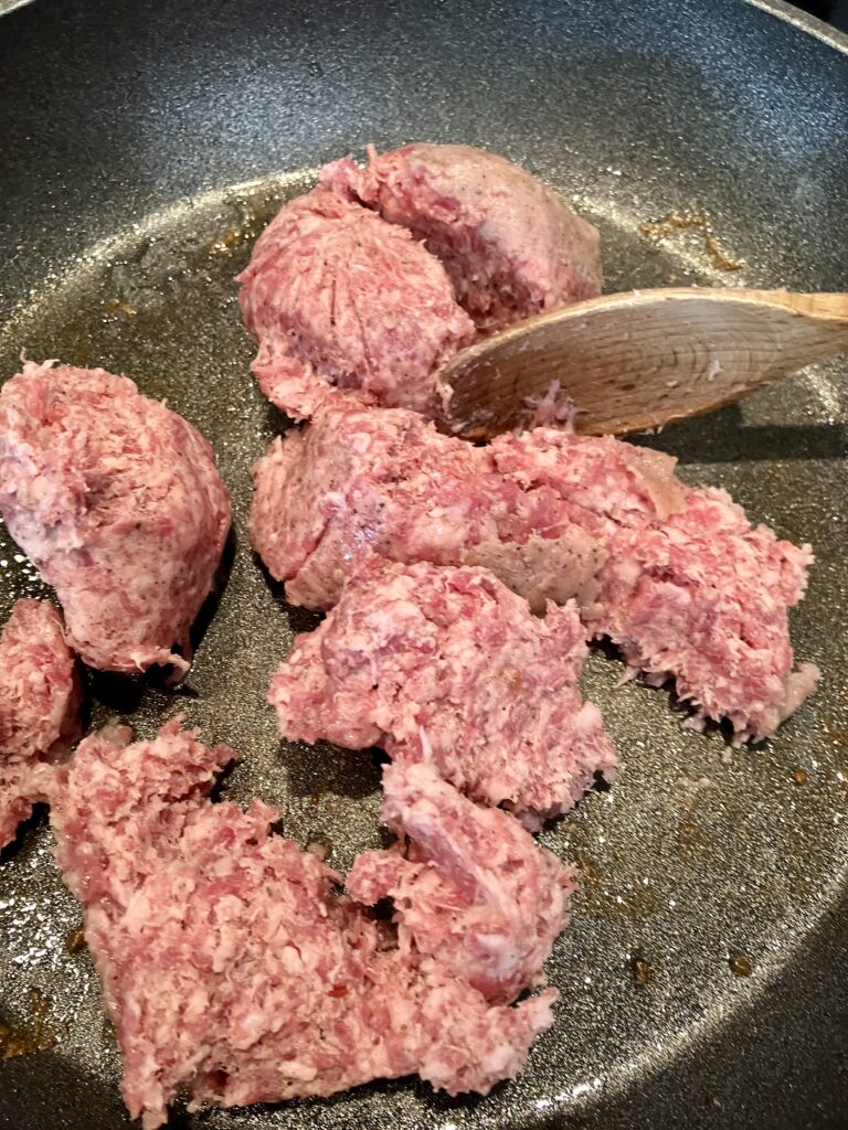 Raw ground sausage in a pan. 