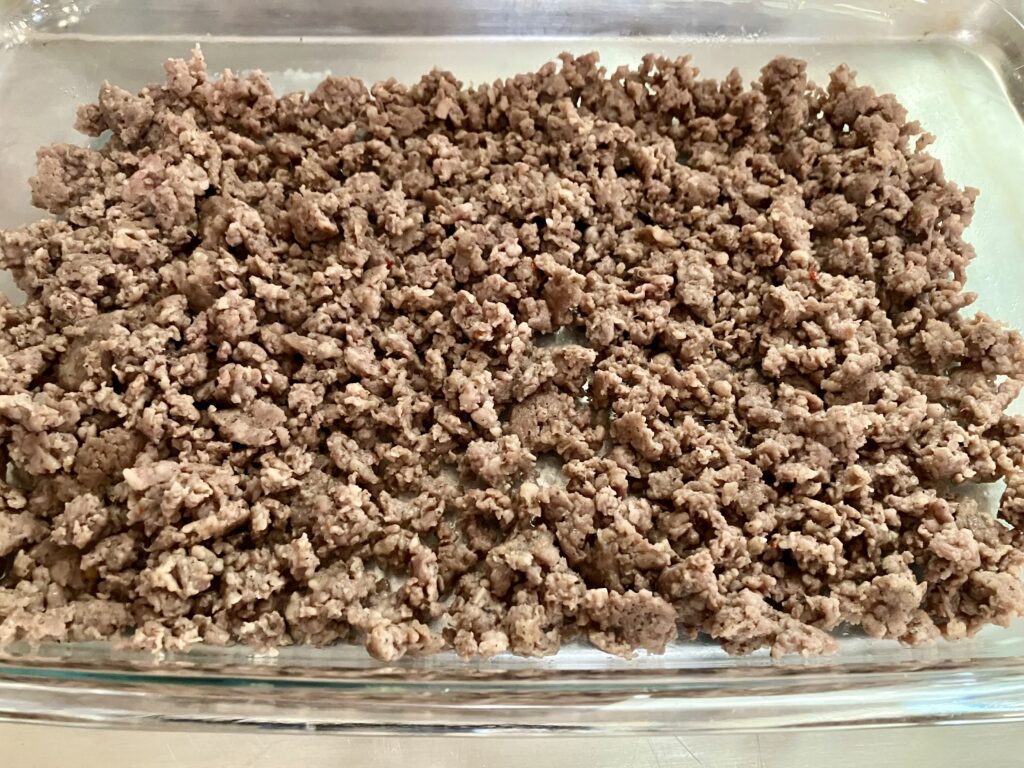 Add ground sausage to a 9 x 13 inch baking dish. 