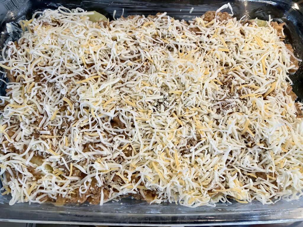 Layer three: potatoes, meat, and cheese. 