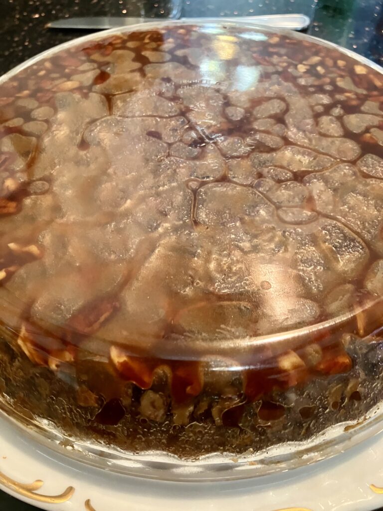 Photo of cake flipped over onto a plate with the cake/pie pan still on the top. 