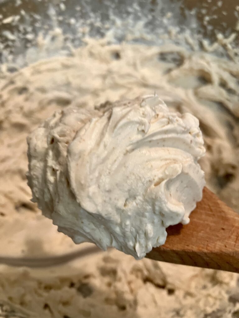 A spoon full of heavy cream whipped to stiff peaks with confectioners sugar, brown sugar and vanilla. 