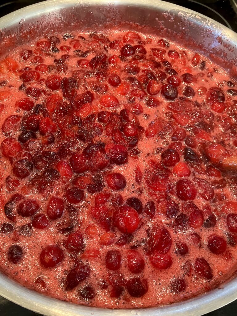 Fresh whole cranberries cooking with cranberry juice, orange juice, sugar, Grand Marnier, Cointreau, Vanilla extract, and ground cinnamon. 