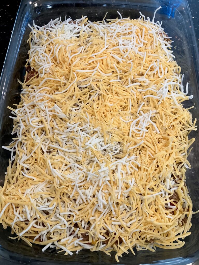 Shredded cheeses over meat sauce. 